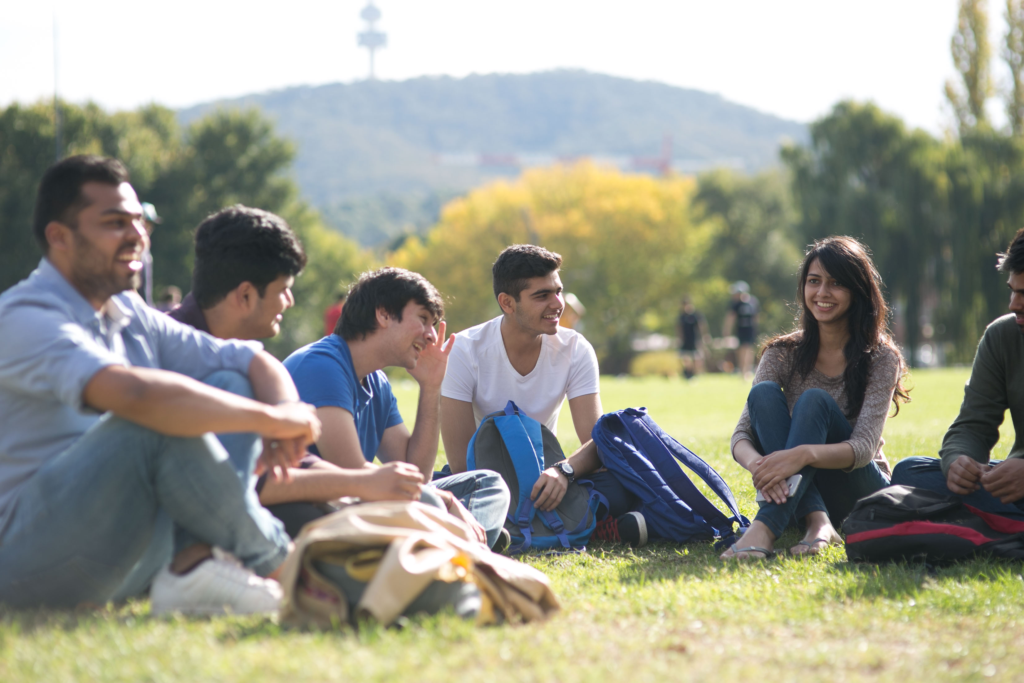 Group of students chatting on grass oval