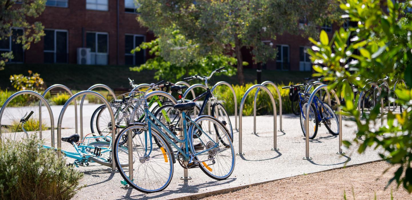 Landscape image of bicycles secured to bicycle racks on ANU campus